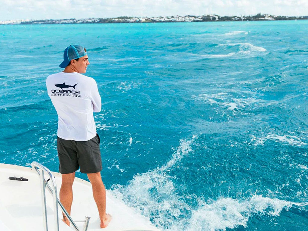 Man standing on boat looking out over the water.