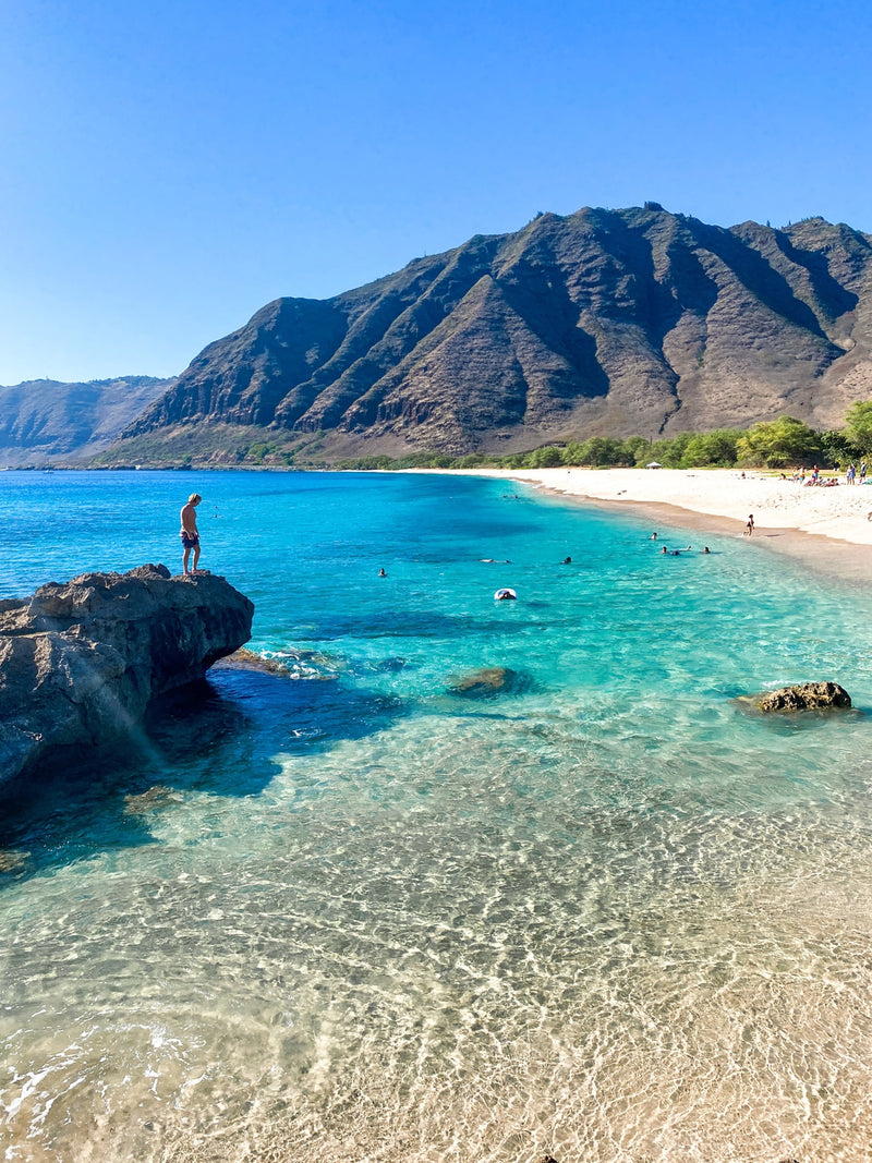 man standing by the ocean on a rock