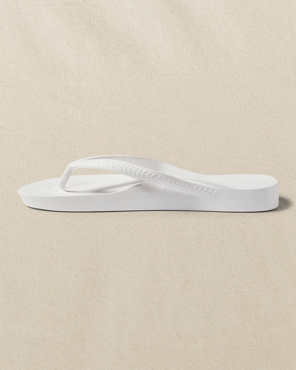 The left side view of the Southern Tide Archies Classic White Arch Support Flip Flop by Southern Tide - Classic White