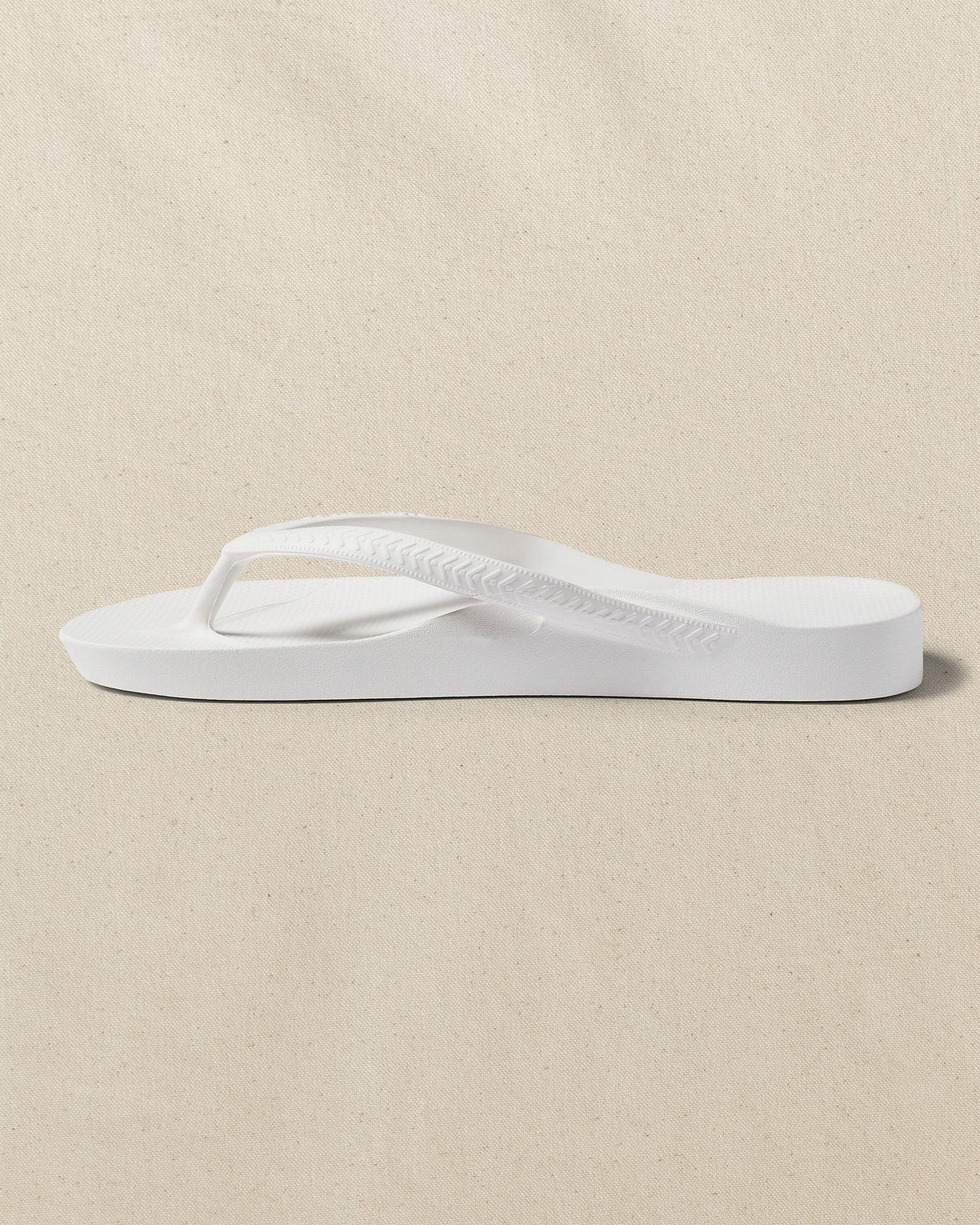 The left side view of the Southern Tide Archies Classic White Arch Support Flip Flop by Southern Tide - Classic White
