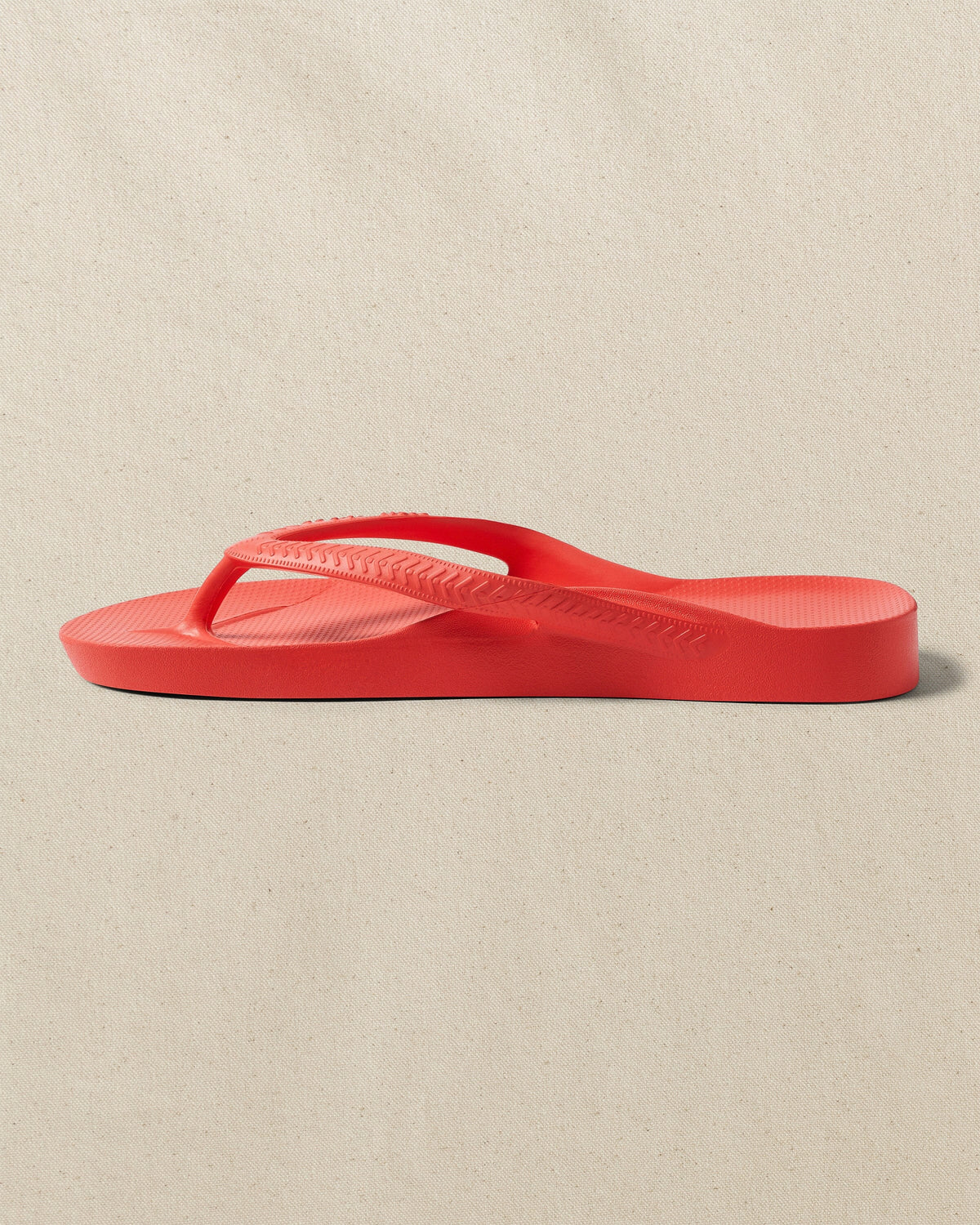 The left side view of the Southern Tide Archie's Coral Arch Support Flip Flop by Southern Tide - Coral