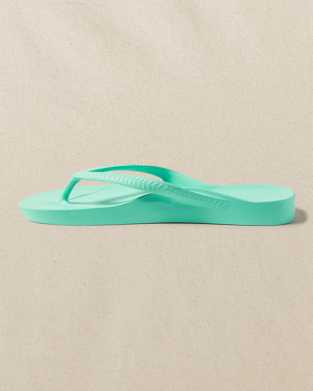 The left side view of the Southern Tide Archies Mint Arch Support Flip Flop by Southern Tide - Mint