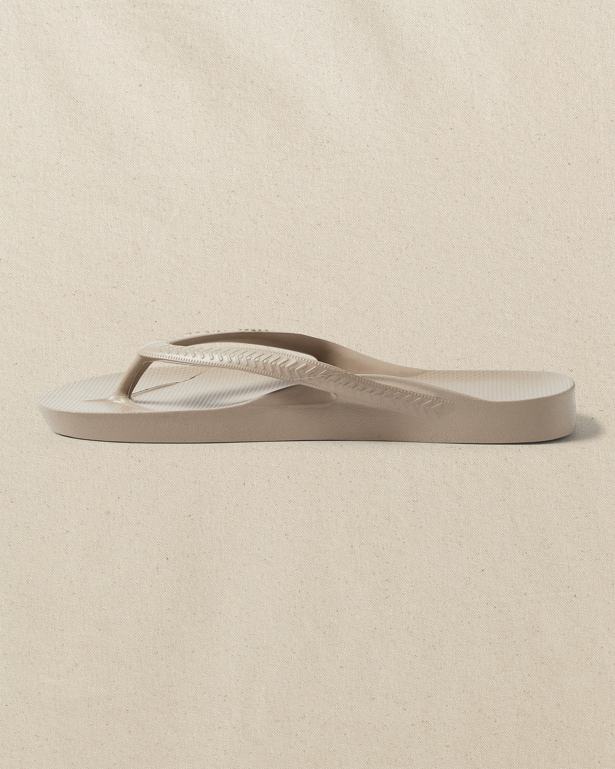 The left side view of the Southern Tide Archie's Taupe Arch Support Flip Flop by Southern Tide - Taupe