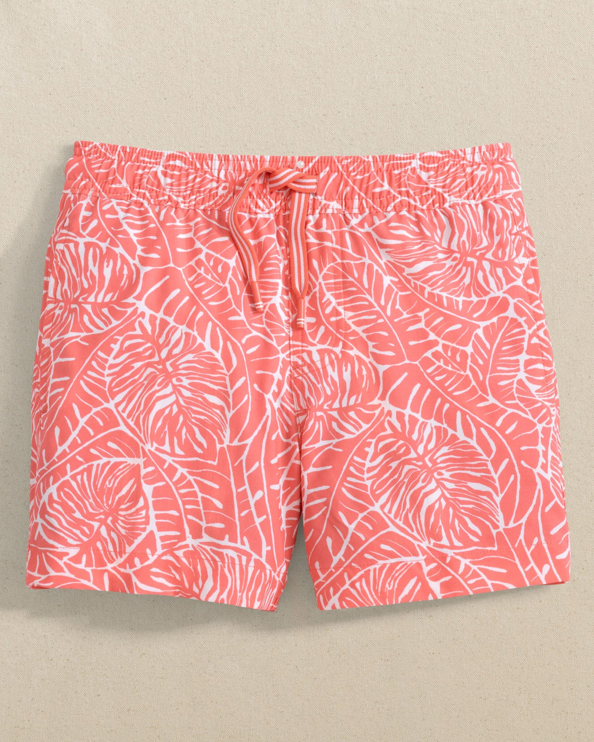 The front view of the Southern Tide Boys Beach Palms Swim Trunk by Southern Tide - Sunkist Coral