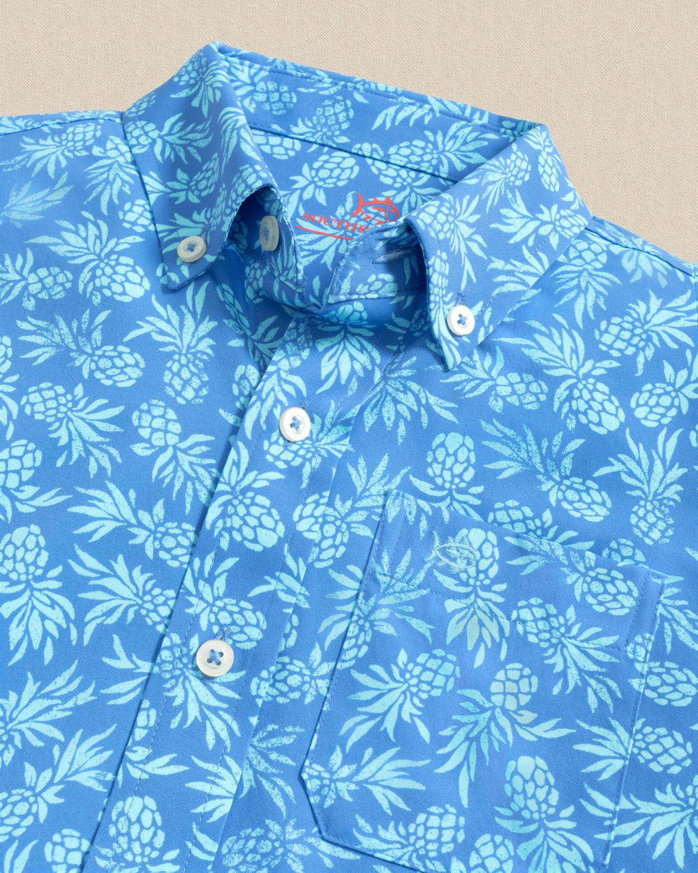 The detail view of the Southern Tide Boys Pineapple Parade Coastal Breeze® Short Sleeve Sport Shirt by Southern Tide - Blue Stream
