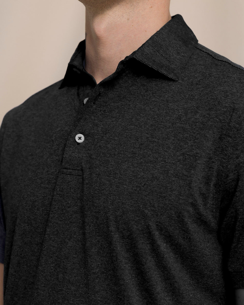 The detail view of the Southern Tide Coastal Breeze® Heather Performance Polo by Southern Tide - Heather Caviar Black
