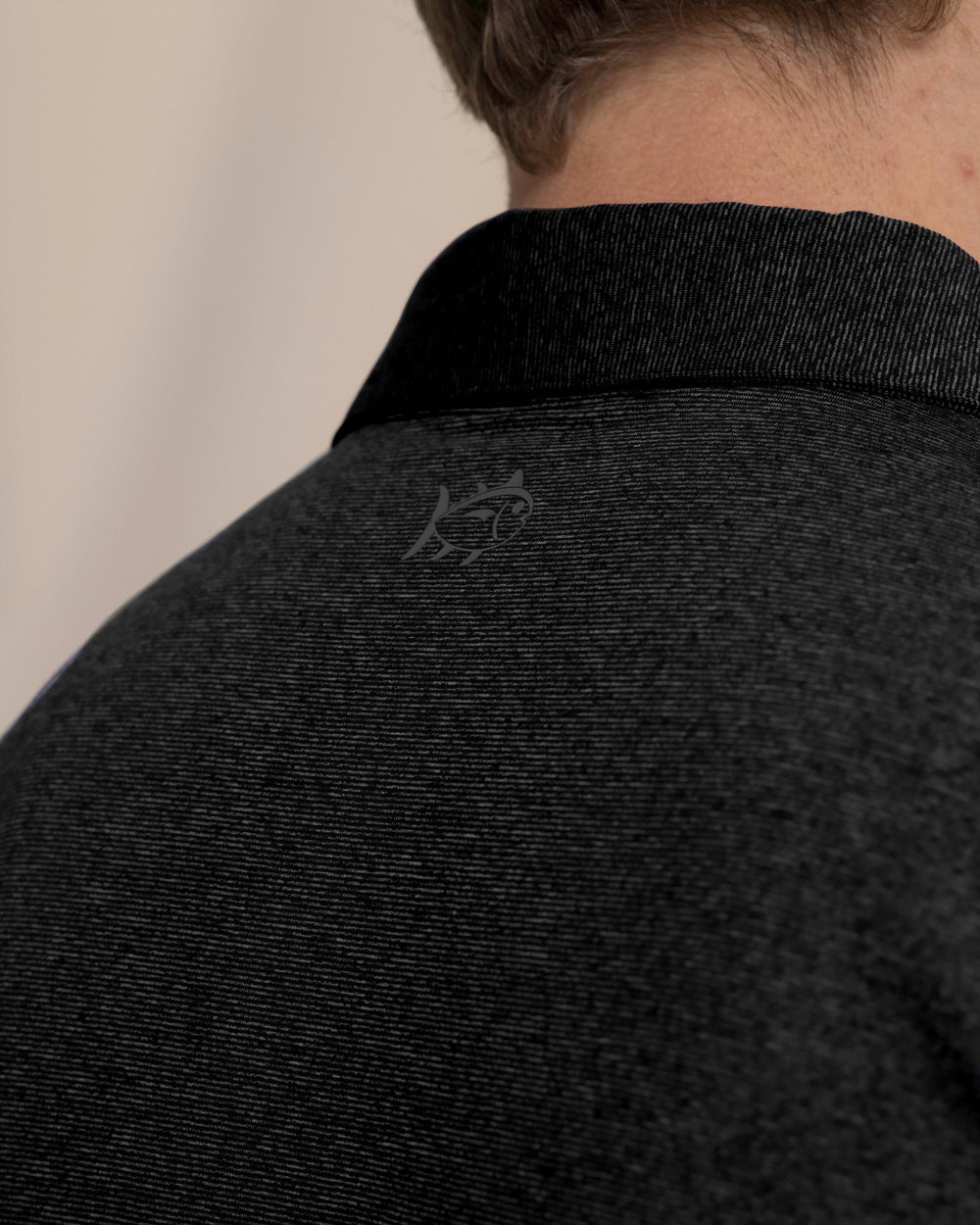 The detail view of the Southern Tide Coastal Breeze® Heather Performance Polo by Southern Tide - Heather Caviar Black