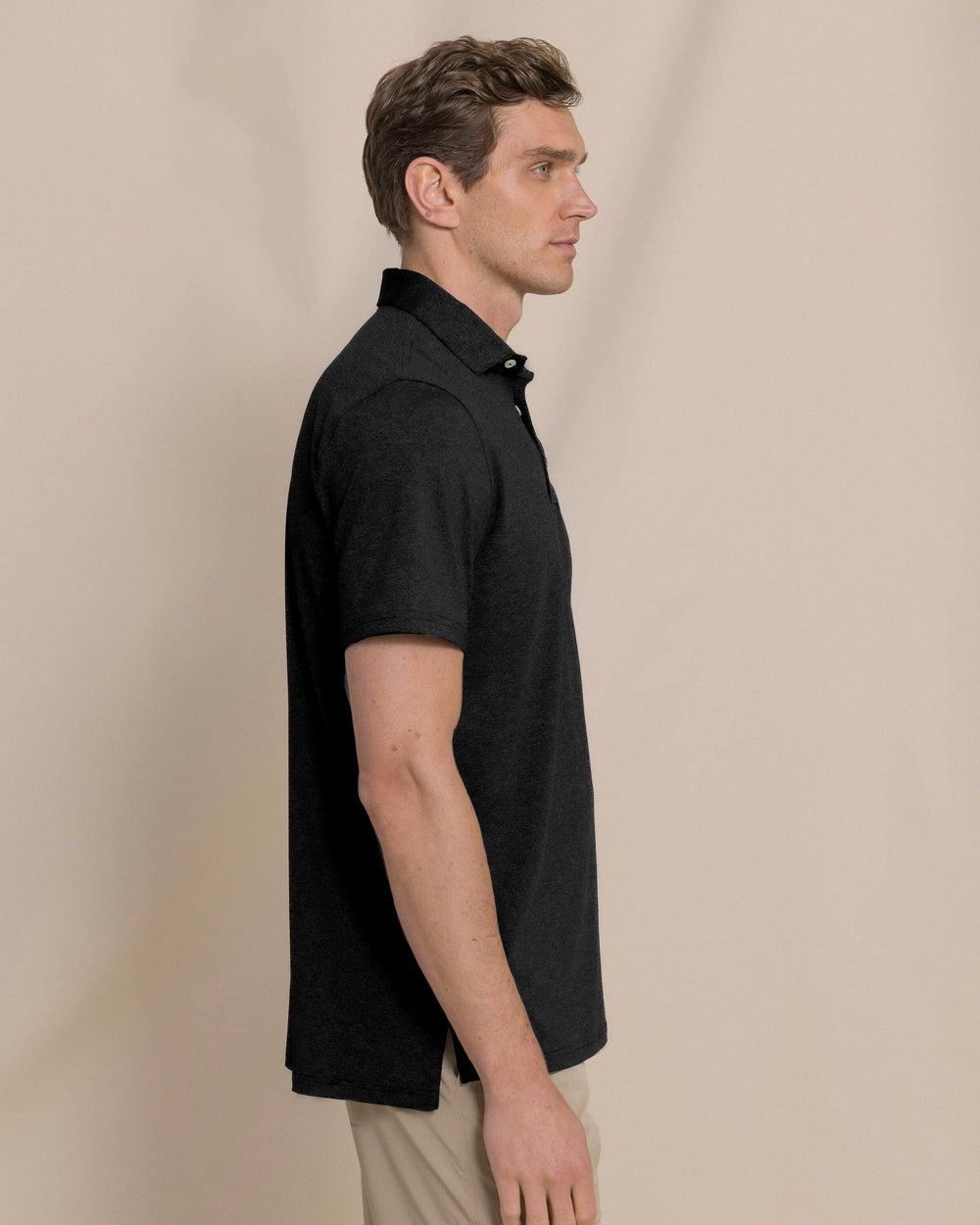 The side view of the Southern Tide Coastal Breeze® Heather Performance Polo by Southern Tide - Heather Caviar Black