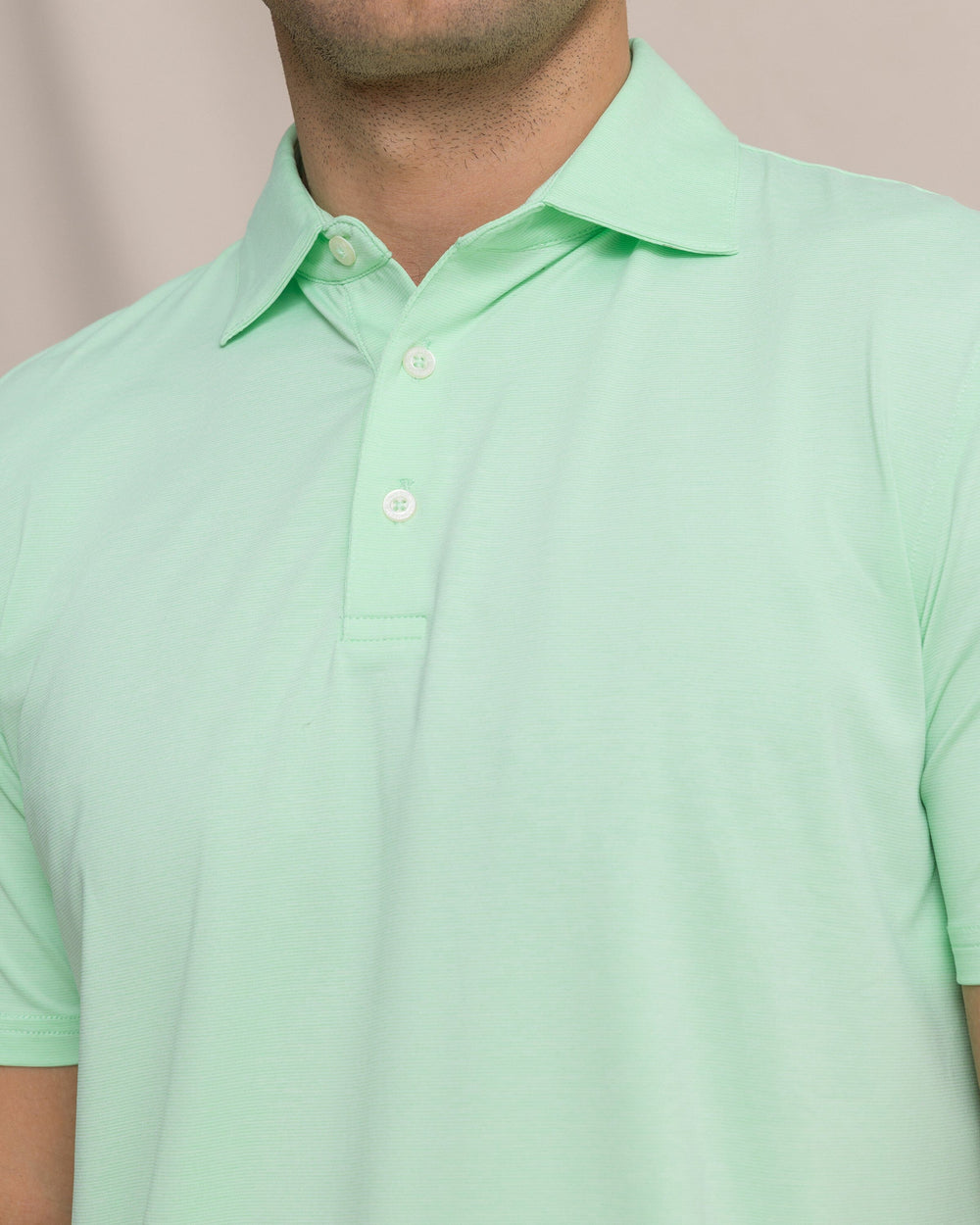 The detail view of the Southern Tide Coastal Breeze® Heather Performance Polo by Southern Tide - Heather Green Ash
