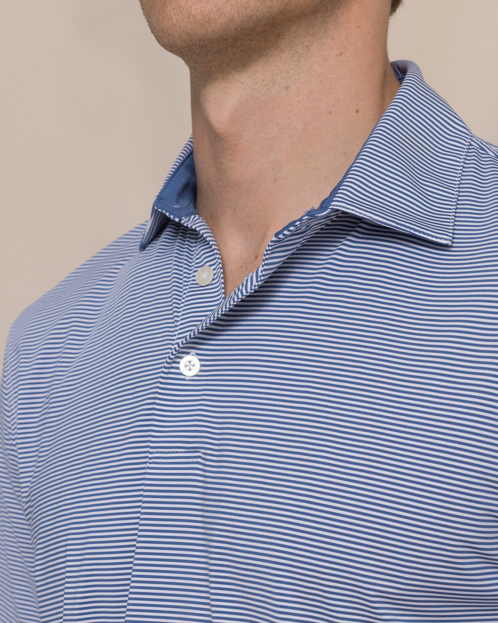 The detail view of the Southern Tide Coastal Breeze® Meadowbrook Stripe Performance Polo by Southern Tide - Aged Denim