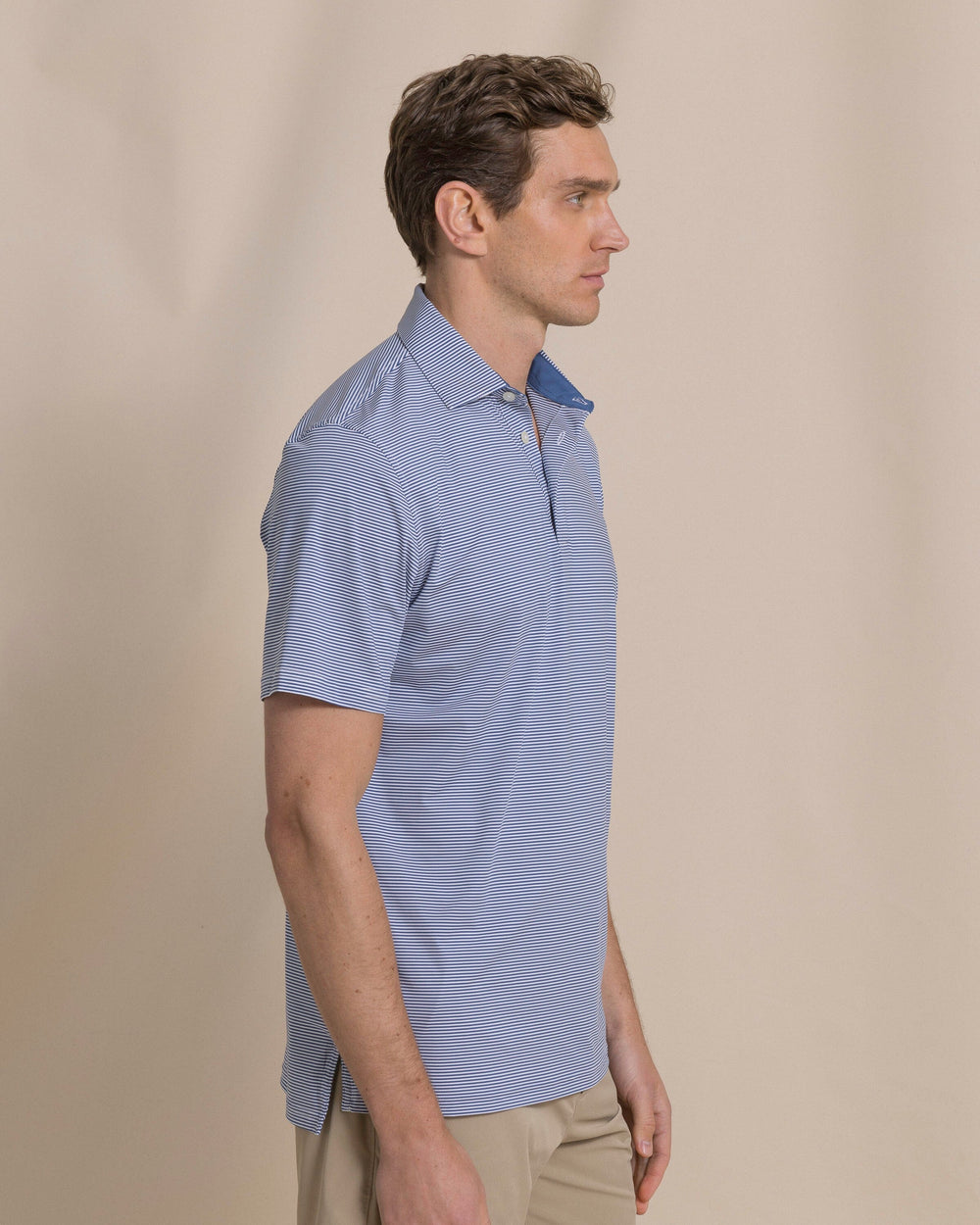 The side view of the Southern Tide Coastal Breeze® Meadowbrook Stripe Performance Polo by Southern Tide - Aged Denim