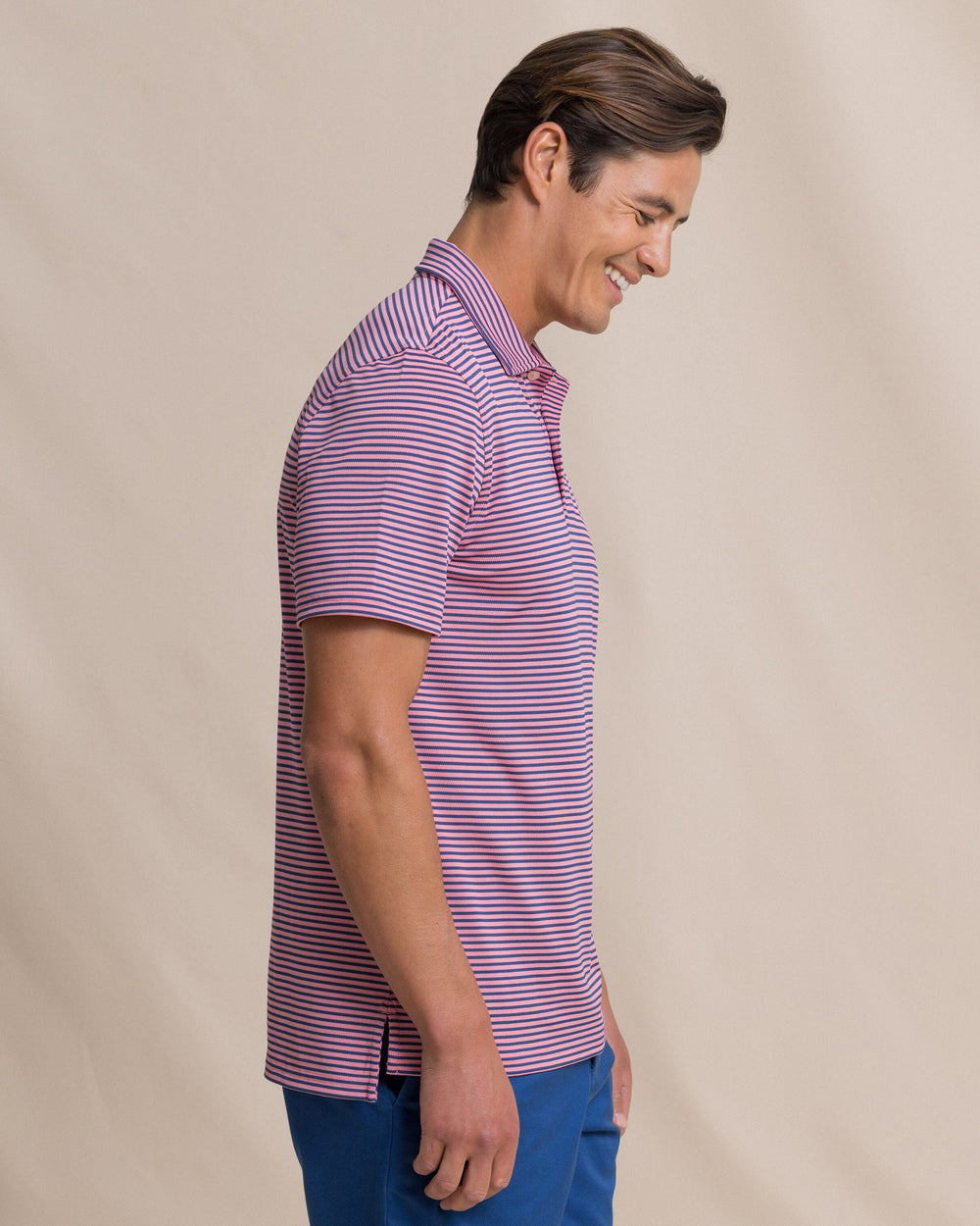 The side view of the Southern Tide Coastal Breeze® Oceanfront Stripe Pique Performance Polo by Southern Tide - Sea Pink