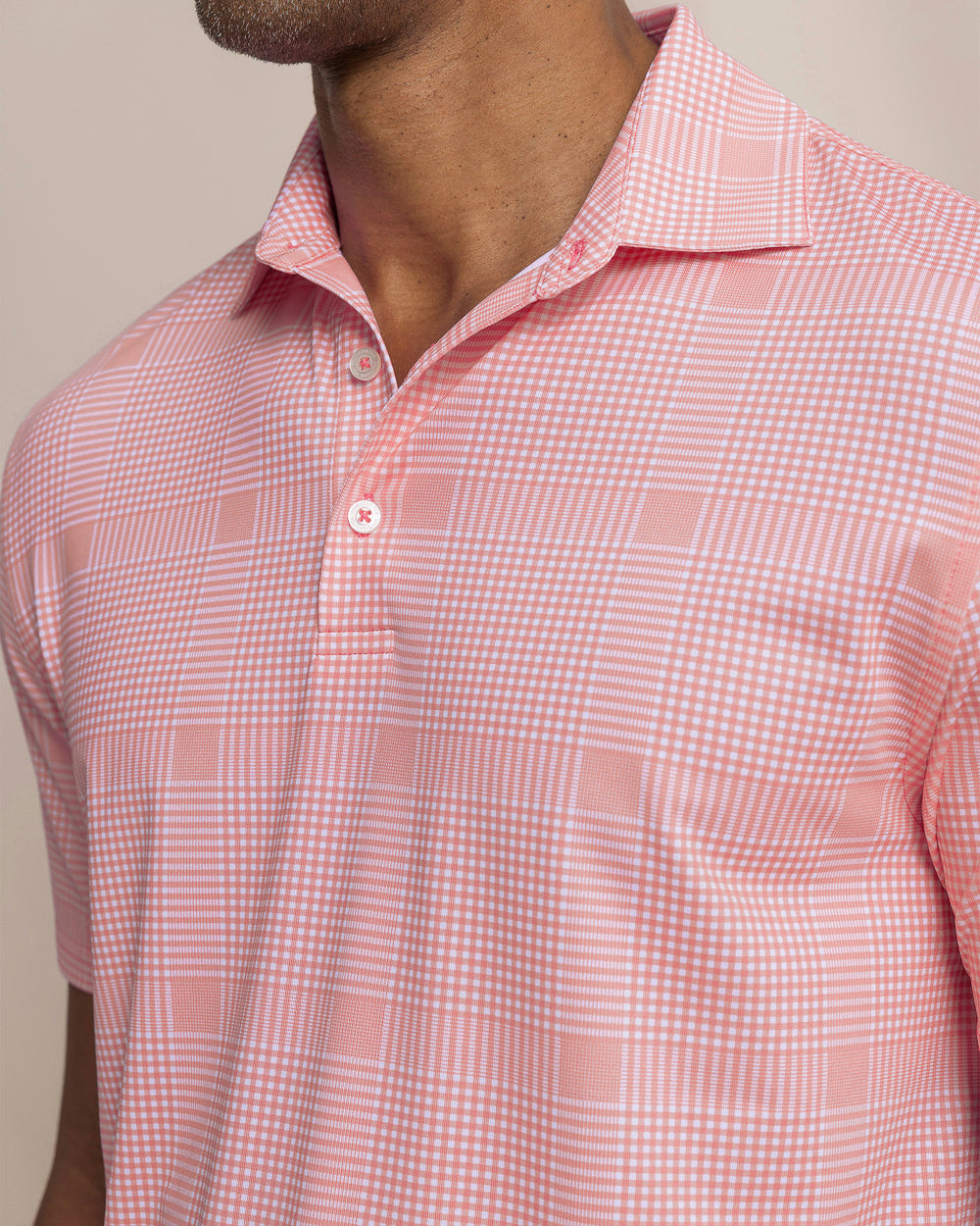 The detail view of the Southern Tide Driver Coral Key Plaid Printed Polo by Southern Tide - Sea Pink