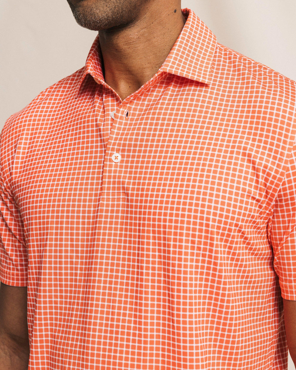 The front detail view of the Southern Tide Driver Dunes Edge Team Colors Plaid Polo by Southern Tide - Endzone Orange