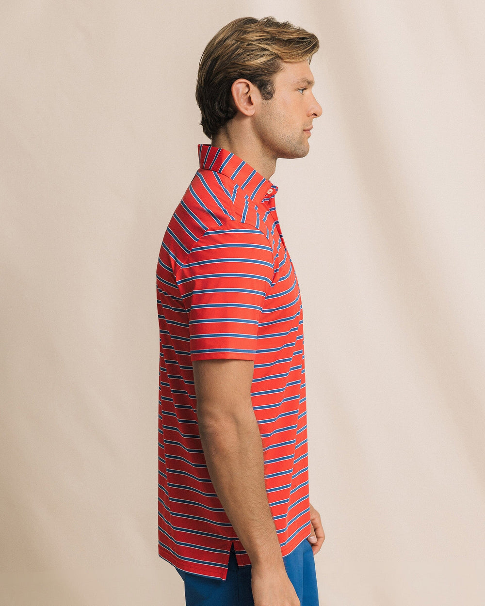 The side view of the Southern Tide Moonlight Bay Stripe Coastal Breeze® Performance Polo by Southern Tide - Channel Marker Red