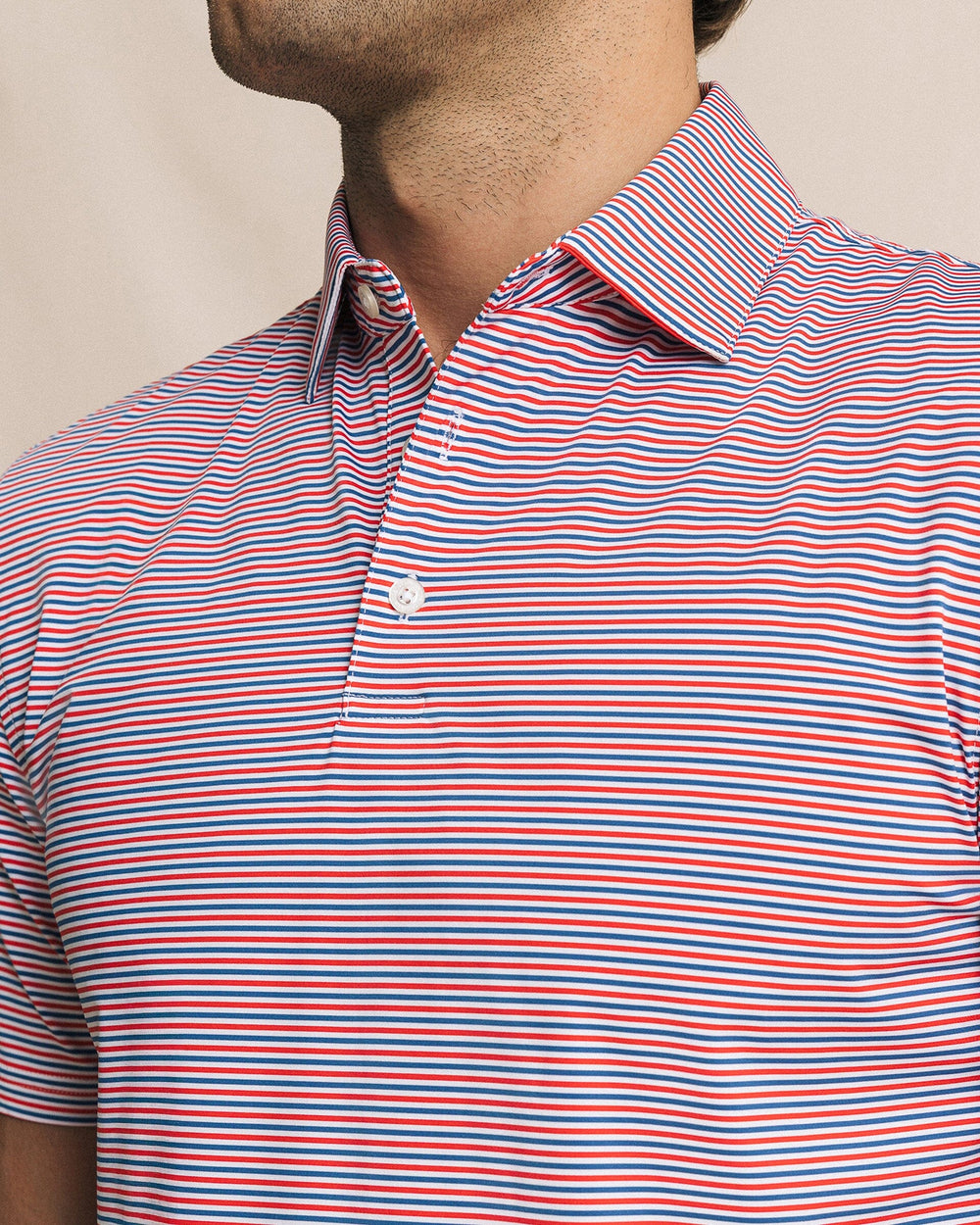 The detail view of the Southern Tide Pelican Landing Stripe Coastal Breeze® Performance Polo by Southern Tide - Channel Marker Red
