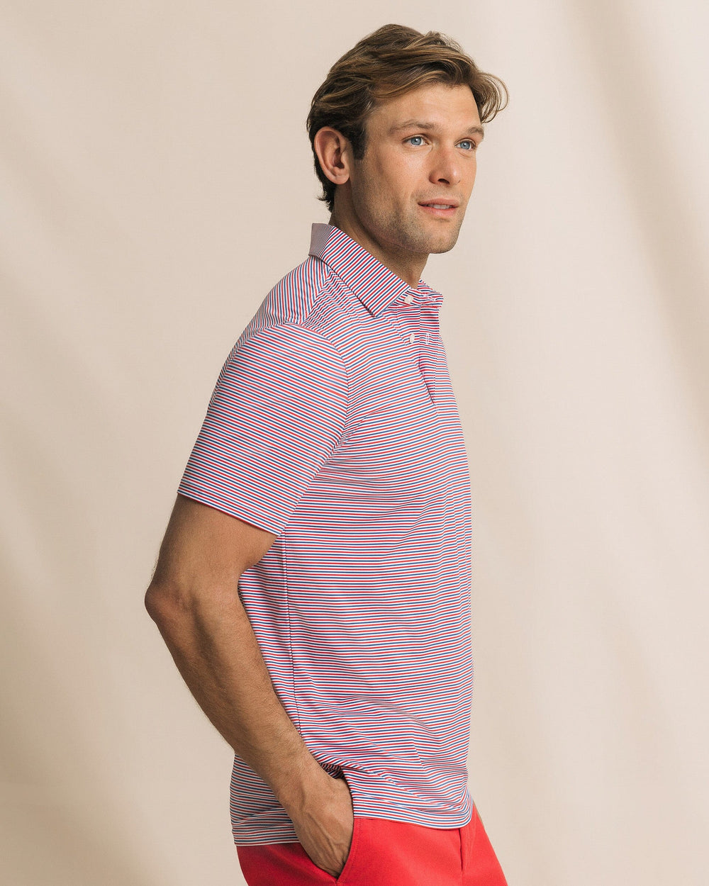 The side view of the Southern Tide Pelican Landing Stripe Coastal Breeze® Performance Polo by Southern Tide - Channel Marker Red