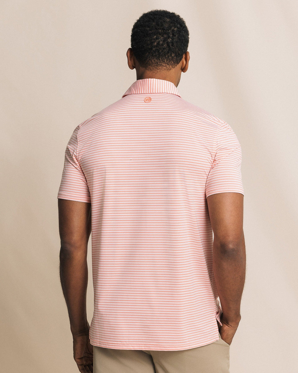The back view of the Southern Tide Pelican Landing Stripe Coastal Breeze® Performance Polo by Southern Tide - Orange Blossom