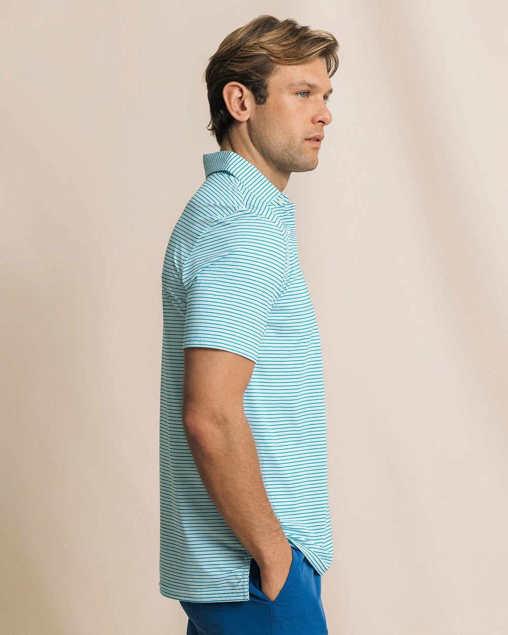 The side view of the Southern Tide Pelican Landing Stripe Coastal Breeze® Performance Polo by Southern Tide - Teal Depths
